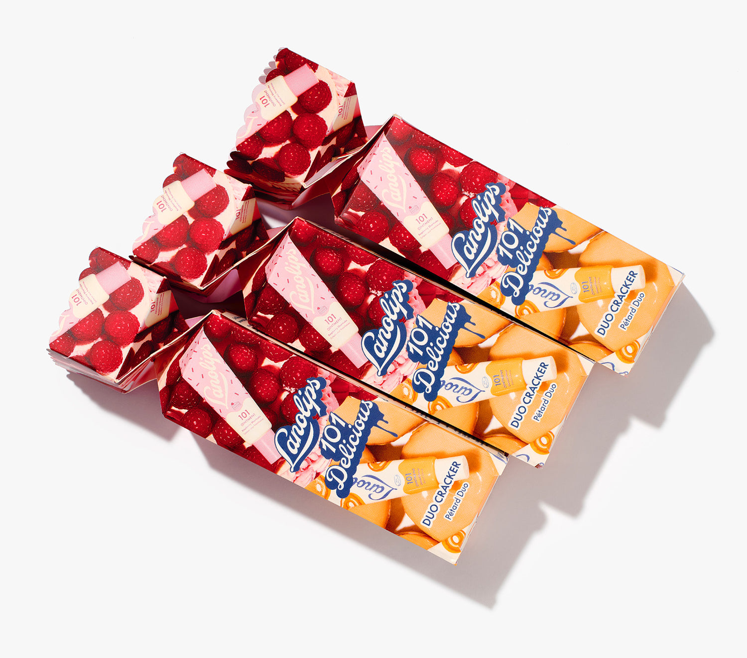 Product shot of multiple Lanolips 101 Delicious Holiday Duo Cracker laid on a white background. The duo contains our best selling glazed donut and raspberry shortcake. With rich lanolin, vitamin E and natural flavours for the ultimate hydration. 