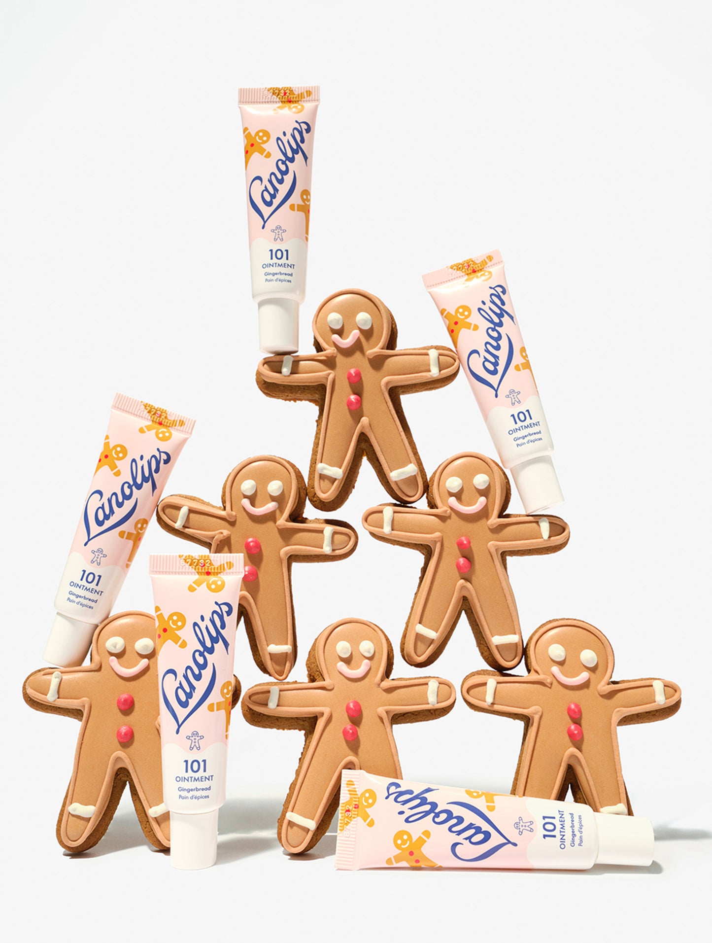 Gingerbread men cookies with Lanolips 101 Ointment Multi-Balm Gingerbread lip balm tubes on a white background.
