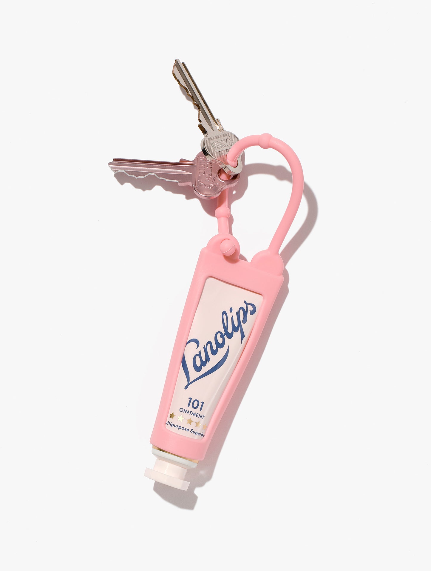 Festive pink key ring with Lanolips lip balm tube, part of the limited-edition holiday collection, placed against a white background.
